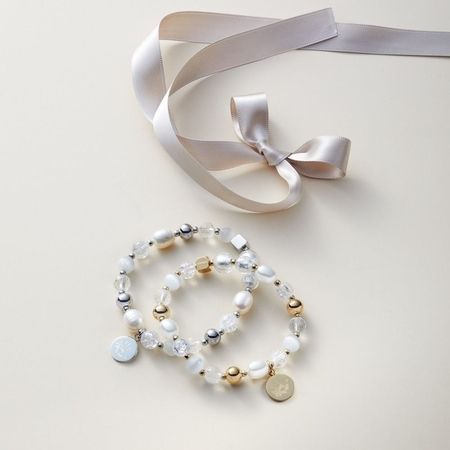 Verspieltes Armband-Set mit bunten Perlen, Muschelelementen und Satinband in Cremeweiß