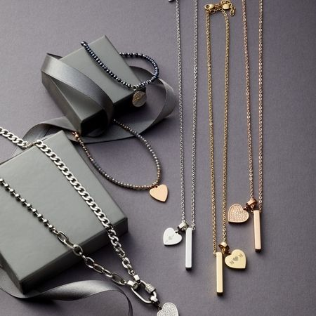 Moderne Schmuckkollektion mit Ketten, Anhängern und Herzen auf stilvoller Präsentationsbox