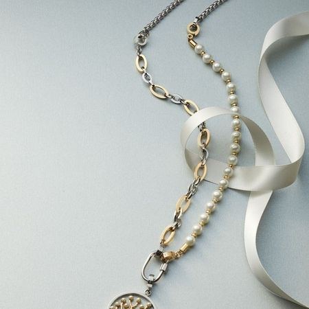 Elegante Kettenkombination in Silber und Gold mit Perlenanhänger und dekorativem Band